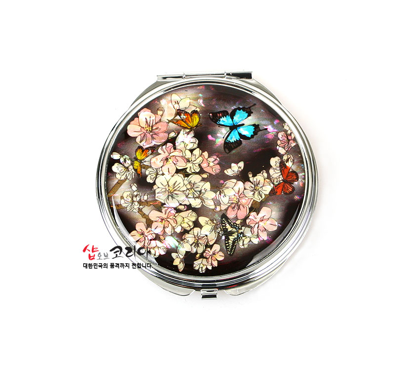 [텍스트: 샵오브코리아 대한민국의 품격까지 전합니다] 자개 상감 기법으로 매화꽃과 청색·주황색 나비 문양을 표현한 원형 금속 손거울 디자인