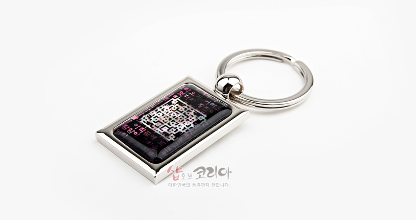 [텍스트: 샵오브코리아 대한민국의 품격까지 전달합니다.] 금속 테두리 안 자개 상감된 시조문 문자와 격자 기하학 문양, 자주·보라색 계열의 열쇠고리 장식