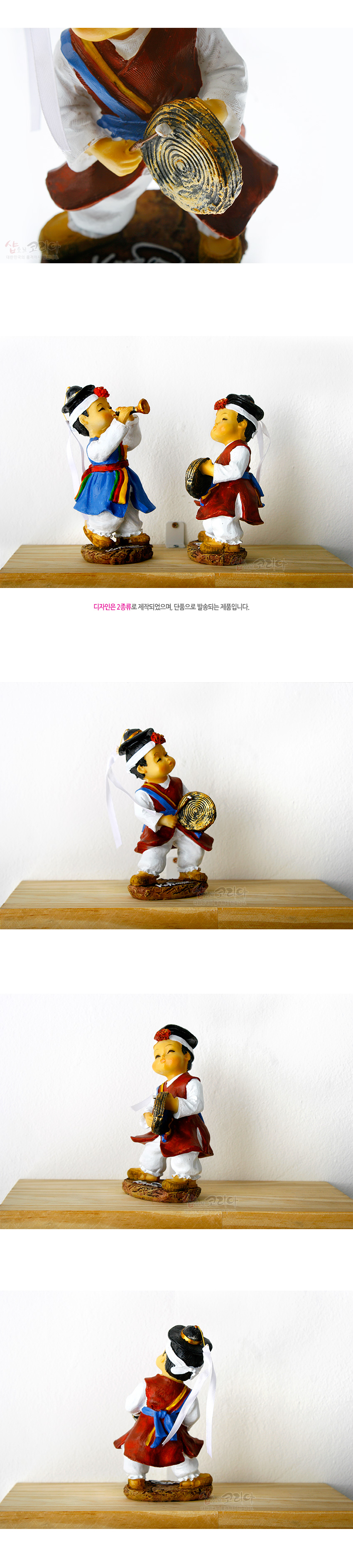 [텍스트: 디자인은 2종류로 제작되어있으며, 단독으로 발송되는 제품입니다.] 채색 레진 재질의 꽹과리 연주 동자상, 붉은색 조끼와 파란색·노란색 띠, 금색 나선 문양 꽹과리와 흰색 긴 수건 장식 특징의 사물놀이 인형 표현