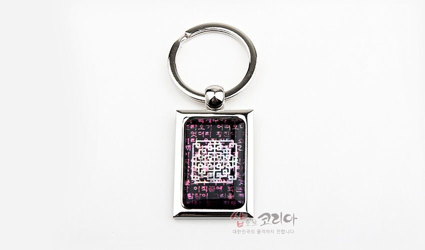 [텍스트: 대한민국의 품격까지 전합니다] 금속 프레임 안 자개 느낌의 보라색 바탕에 시조문 문자와 기하학적 QR 패턴이 어우러진 직사각 열쇠고리 디자인