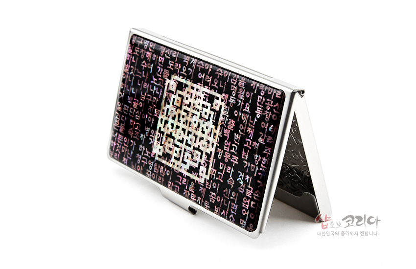 [텍스트: (부분적으로 보이는 한글 시조문 텍스트)] 자개 상감 기법으로 한글 시조문과 중앙 기하학 문양을 표현한 금속 명함집, 흑자주색 바탕의 오묘한 빛감 연출