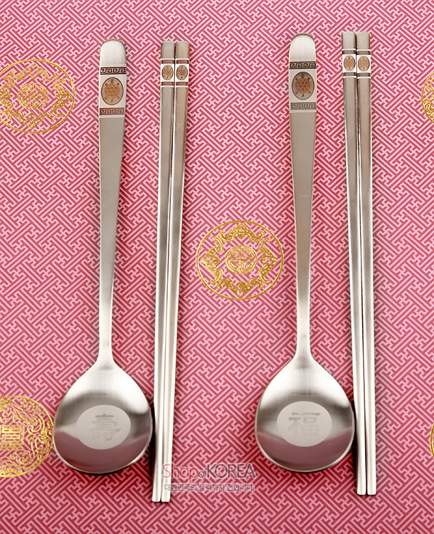 [텍스트: ShopKOREA] 스테인리스 재질, 손잡이 상단 거북이와 기하학 무늬 장식, 숟가락 바닥 복자 음각, 분홍 바탕 전통 문양 배경 연출