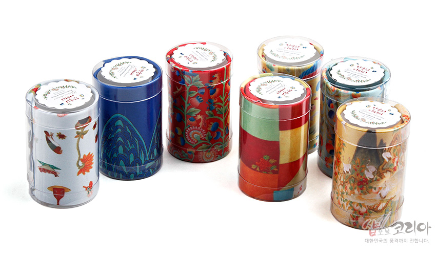 [텍스트: KOREA traditional 디자인 안경 닦이] 전통 조각보와 화조도, 산수문 등 다채로운 민화풍 문양이 인쇄된 원통형 패키지 속 극세사 안경닦이 디자인 모습