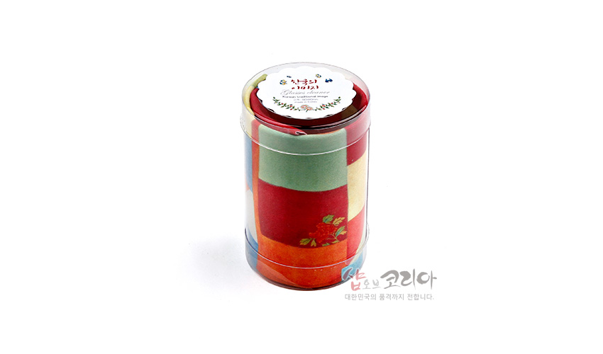 [텍스트: 샵오브코리아, 대한민국의 품격까지 전합니다.] 원형 투명 케이스에 담긴 극세사 재질 전통 조각보 패턴 안경닦이, 적색·녹색·황색 사각 색면과 작은 꽃문양이 어우러진 디자인