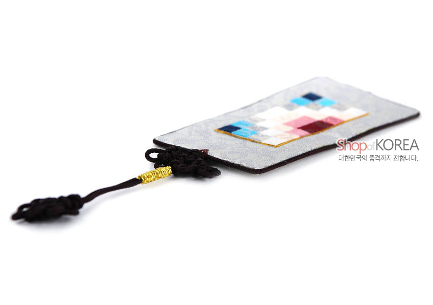 [텍스트: Shop of KOREA / 대한민국의 품격까지 전합니다.] 은색 비단 바탕에 분홍·파랑·흰색 전통 조각보 패치워크와 금사 장식 흑색 매듭끈이 어우러진 직사각형 책갈피 모습