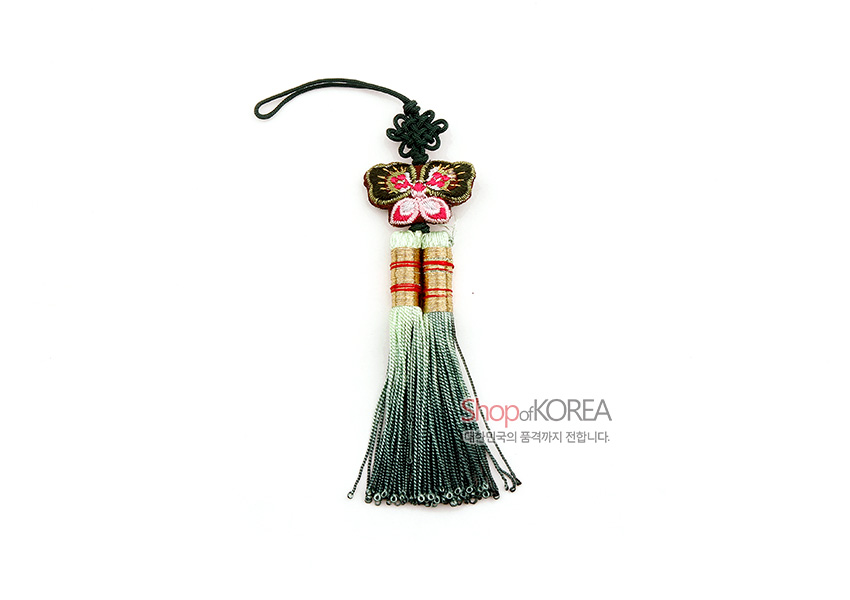 [텍스트: ShopofKOREA 대한민국의 품격까지 전합니다.] 자수 나비 장식과 흑색 매듭 위에 연두에서 먹색으로 그라데이션된 술이 이어진 전통 실매듭 장식 디자인