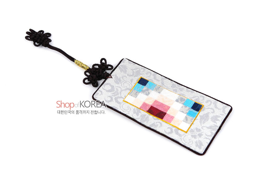 [텍스트: Shop of KOREA / 대한민국의 품격까지 전합니다.] 은색 문양 비단 바탕에 분홍·청색·흰색 조각보 패치워크와 금사 장식 흑색 매듭끈이 더해진 직사각형 책갈피형 장식