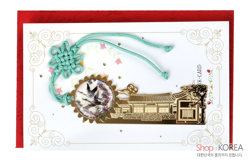 [텍스트: Shop of KOREA / 대한민국의 품격까지 전합니다.] 금속 재질 기와집 문양 책갈피와 자개 상감 쌍학 장식, 청록색 전통 매듭 끈 포인트 디자인