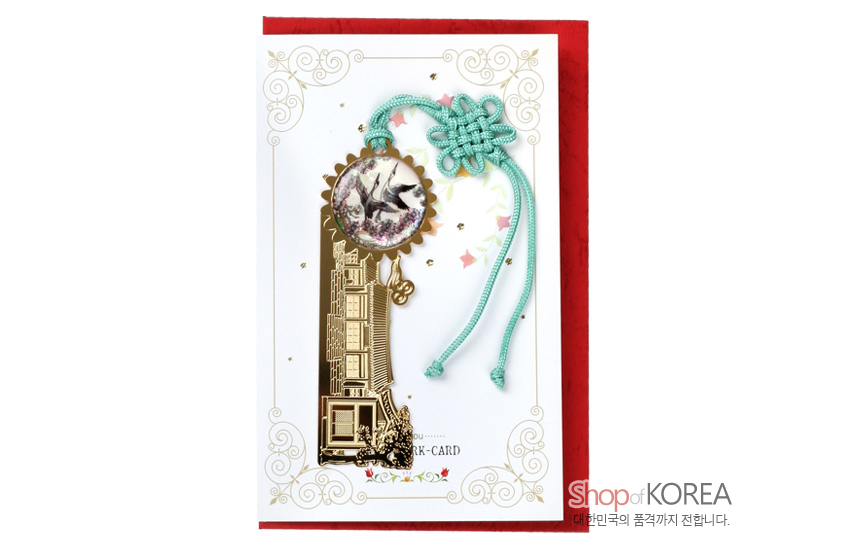 [텍스트: Shop of KOREA, 대한민국의 품격까지 전합니다.] 금장 금속 위 기와집 문양과 원형 자개 쌍학 상감, 청록색 전통 매듭 장식이 어우러진 책갈피 이미지