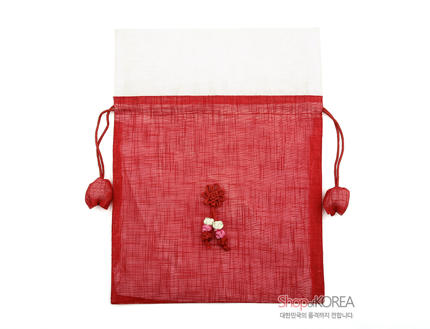 [텍스트: Shop of KOREA 대한민국의 품격까지 전합니다.] 붉은 모시와 흰색 모시 배색의 평면형 복주머니, 중앙 꽃매듭과 하단 복숭아 매듭 장식, 양쪽 끈 끝 복숭아 모양 장식 특징의 전통 매듭 주머니 형상