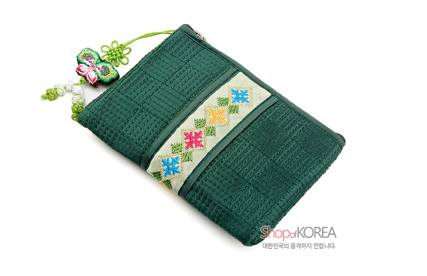 [텍스트: Shop of KOREA 대한민국의 품격까지 전합니다.] 짙은 녹색 비단 누비 바탕에 사각 격자 무늬와 오방색 기하학 자수 띠, 나비 매듭 술 장식이 어우러진 전통 동전지갑