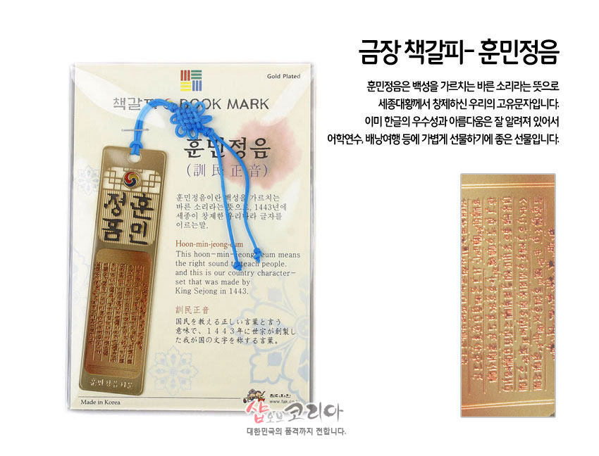 [텍스트: 금장 책갈피-훈민정음, BOOK MARK, 훈민정음(訓民正音), Made in Korea 외 한글·영문 설명문] 금장 처리된 금속 직사각 책갈피와 태극 문양, 음각된 훈민정음 서문, 청색 전통 매듭 끈 장식 이미지 설명
