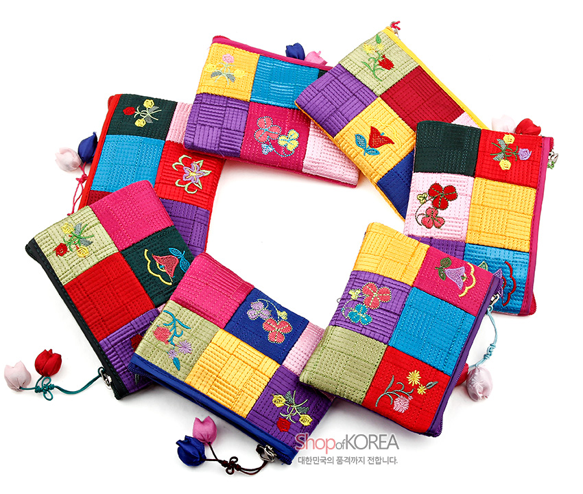 [텍스트: Shop of KOREA 대한민국의 품격까지 전합니다.] 색동 비단 누비 패치워크 바탕에 꽃과 나비 자수 장식, 조각보 무늬와 매듭술 지퍼 장식 동전지갑들 모습