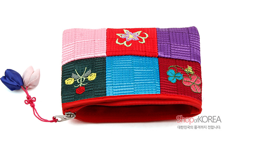 [텍스트: ShopofKOREA 대한민국의 품격까지 전합니다.] 비단 누비 패치워크 조각보 바탕, 다채로운 색동 사각 구성과 꽃·나비 자수 문양, 매듭 장식 지퍼 여밈 동전지갑 이미지 설명