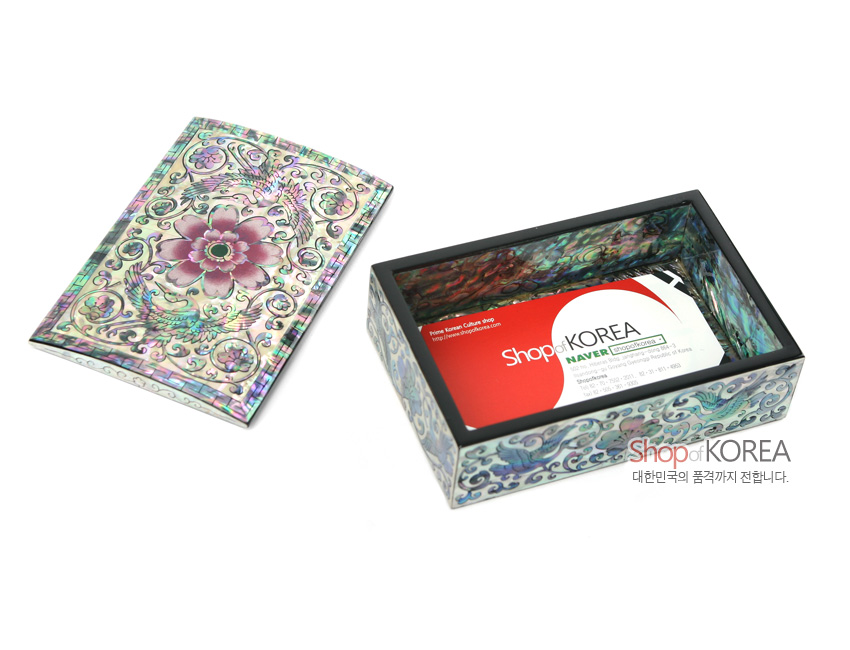 [텍스트: Shop of KOREA 대한민국의 품격까지 전합니다.] 흑색 옻칠 바탕에 자개 상감으로 당초무늬와 쌍학, 연꽃을 은은한 자색과 청록색으로 장식한 직사각 명함함 이미지 설명