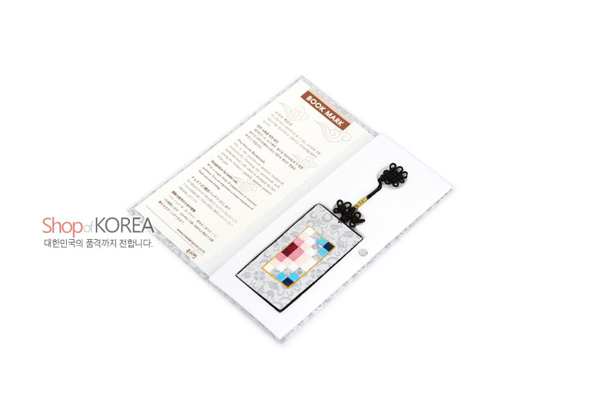 [텍스트: Shop of KOREA, BOOK MARK, 대한민국의 품격까지 전합니다.] 은색 비단 바탕에 분홍·파랑·흰색 전통 조각보 패치워크와 흑색 매듭끈 장식의 직사각형 책갈피 이미지