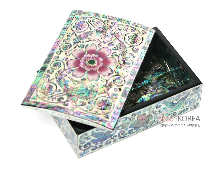 [텍스트: Shop of KOREA 대한민국의 품격까지 전합니다.] 흑색 옻칠 바탕 위 자개 상감 기법으로 연분홍 꽃과 쌍학, 당초무늬를 정교하게 장식한 직사각 명함함 이미지