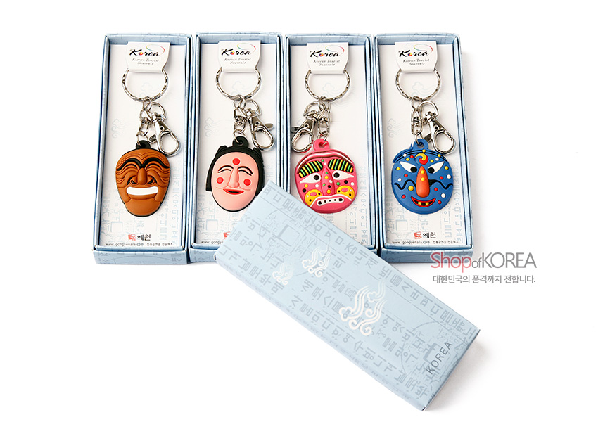 [텍스트: Korea, Shop of KOREA, 대한민국의 품격까지 전합니다.] 파스텔 블루 한글 문양 종이 케이스에 담긴 실리콘 하회탈 얼굴 장식과 금속 체인, 고리로 구성된 4종 열쇠고리 세트 이미지 설명