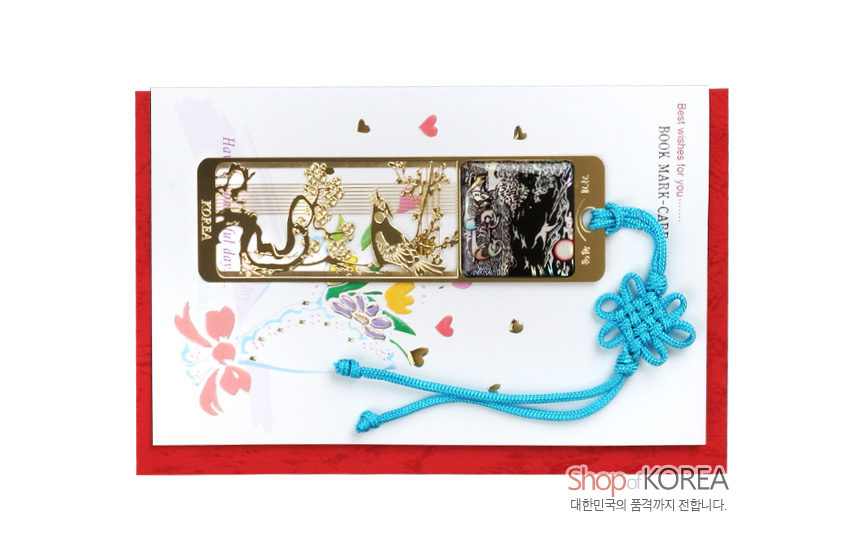 [텍스트: KOREA, Best wishes for you…, BOOK MARK·CARD, Shop of KOREA, 대한민국의 품격까지 전합니다.] 금속 오픈워크에 원앙과 꽃 문양을 새기고 흑색 바탕 자개 상감과 청색 전통 매듭 끈을 더한 책갈피 장식