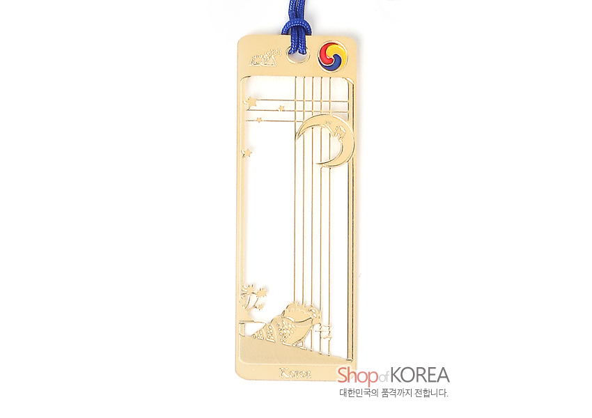 [텍스트: KOREA, Shop of KOREA, 대한민국의 품격까지 전합니다.] 금장 금속 재질 오픈워크 기법 직사각 책갈피, 초승달과 별, 고동 문양, 상단 태극 문양과 청색 끈 장식 디자인