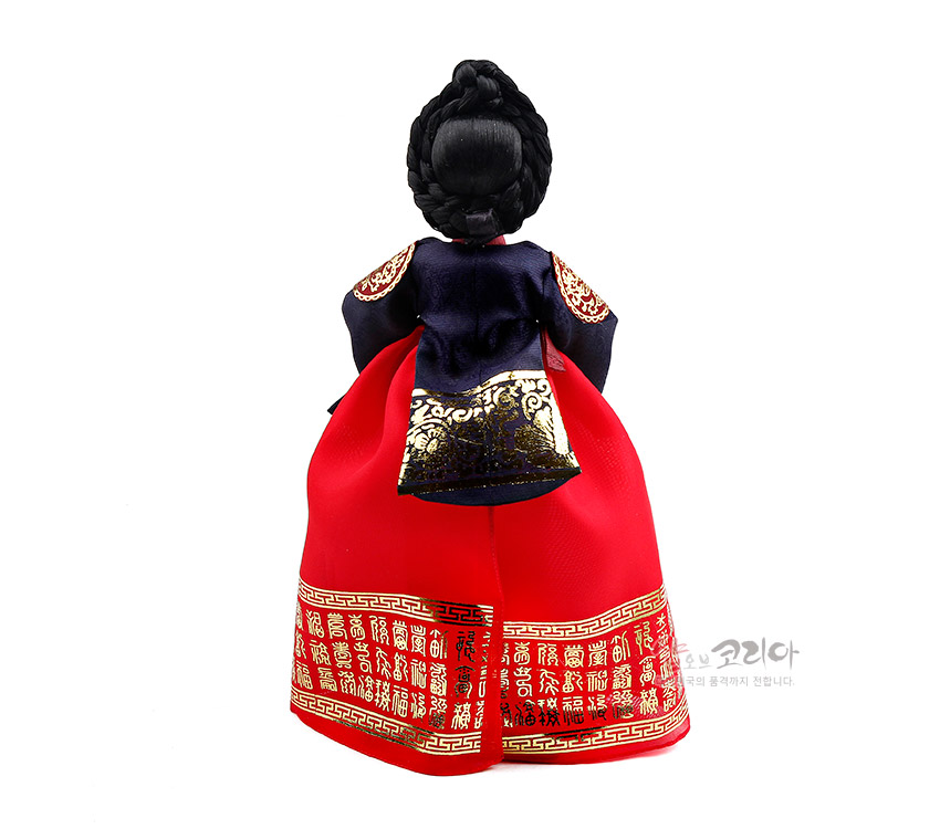 [텍스트: 샵오브코리아] 붉은 비단 치마 단에 금색 문자·전통문양을 촘촘히 배치하고, 남색 당의에 금박 보문을 더한 궁중 한복 인형의 뒷모습 연출