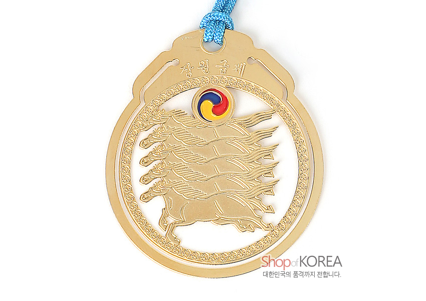 [텍스트: 장원급제, Shop of KOREA, 대한민국의 품격까지 전합니다.] 금속 재질 금장 마패 모양 책갈피, 다섯 마리 말 문양과 원형 태극 문양, 하늘색 전통 매듭 끈 장식 디자인