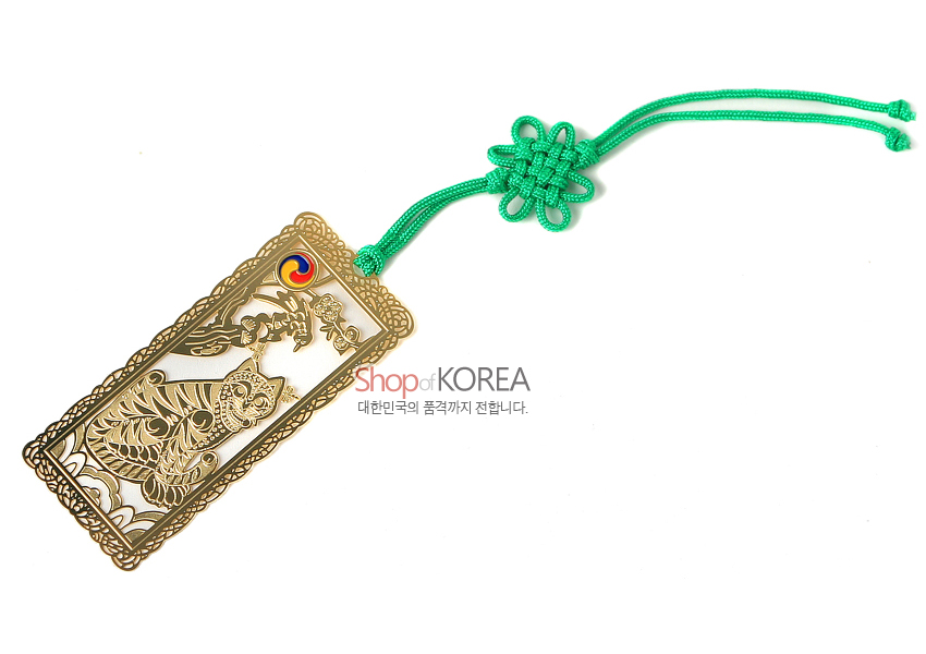 [텍스트: ShopofKOREA 대한민국의 품격까지 전합니다.] 금속 재질에 금장 처리된 직사각형 책갈피, 작호도 문양과 삼태극 채색, 초록색 전통 매듭끈 장식