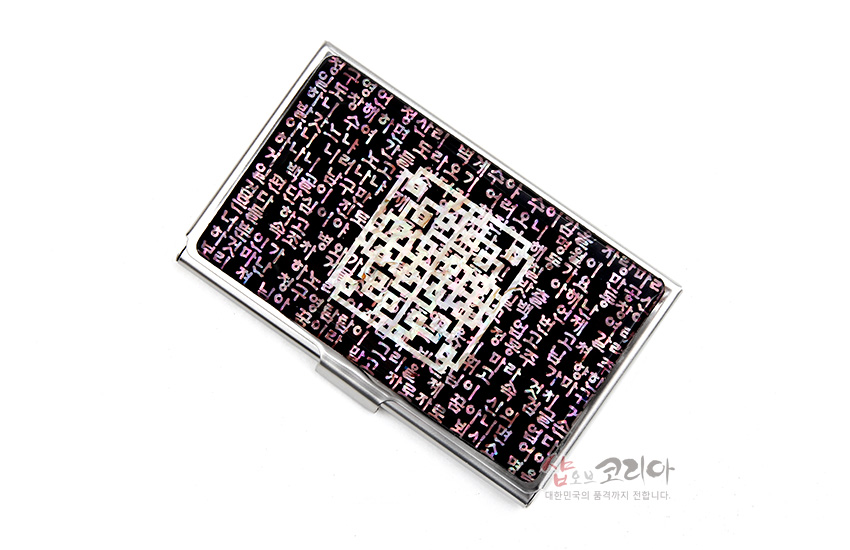 [텍스트: 샵오브코리아 대한민국의 품격까지 전합니다] 검정 바탕 위에 자개 상감으로 표현한 시조문의 한글 문자와 중앙 자개 QR코드형 기하 문양이 어우러진 금속 명함집 디자인