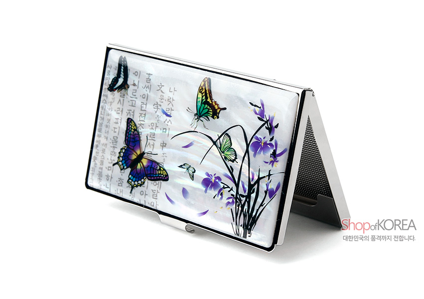 [텍스트: Shop of KOREA 대한민국의 품격까지 전합니다.] 자개 상감 기법으로 흰색 바탕 위에 난초와 나비 문양을 섬세하게 표현한 금속 명함케이스 디자인