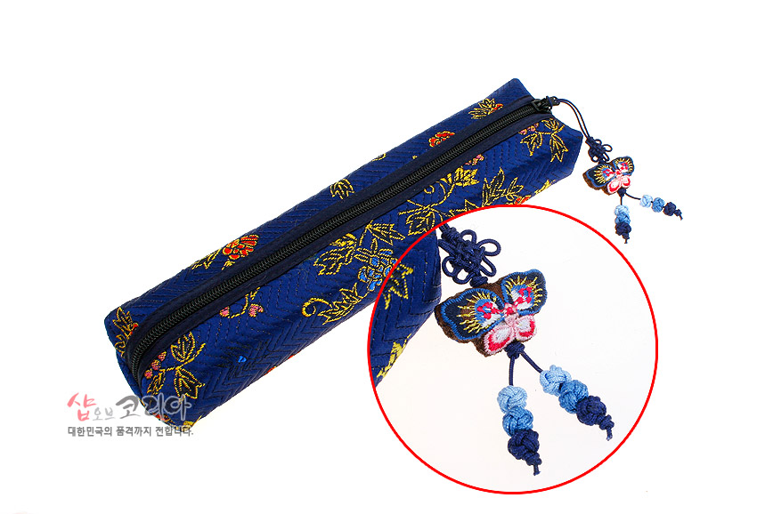 [텍스트: 샵오브코리아 대한민국의 품격까지 전달합니다.] 남색 비단 누비 필통, 금색 꽃과 나비 자수 문양, 나비 모양 자수 술과 청색 매듭 장식 지퍼 손잡이 디자인