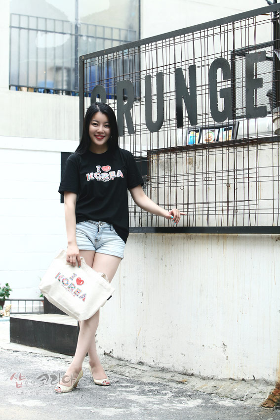 [텍스트: GRUNGE / I ♥ KOREA] 흑색 면 티셔츠에 컬러풀한 입체발포 I ♥ KOREA 레터링과 아이콘 장식이 돋보이는 캐주얼 연출