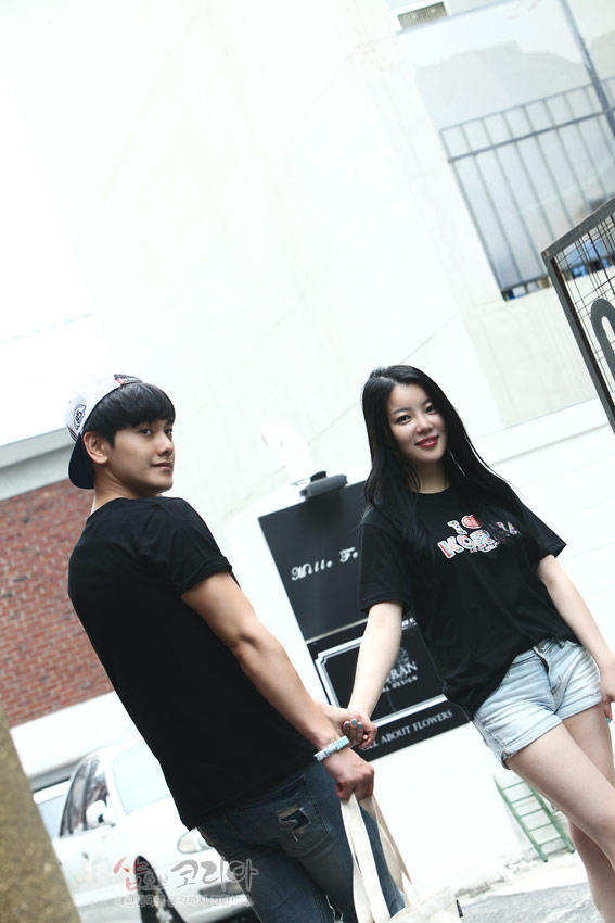 [텍스트: I ♥ KOREA] 흑색 면 티셔츠에 컬러 입체발포 기법으로 표현된 영문 레터링과 하트 장식의 캐주얼 커플 연출 이미지