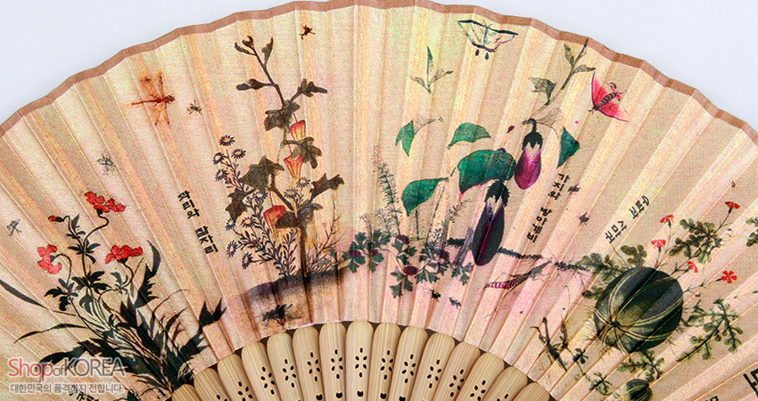 [텍스트: 석곡과 잠자리 / 수박과 들쥐 / ShopofKOREA 대한민국의 품격까지 전합니다] 실크 재질 위에 초충도 민화와 곤충, 한자 서예를 섬세한 채색으로 표현한 전통 접이부채 디자인
