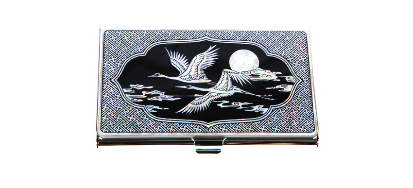 흑색 바탕 위 자개 상감으로 달과 구름, 두 학 문양을 넣고 주변을 기하학 연속무늬 자개로 장식한 금속 명함함 디자인