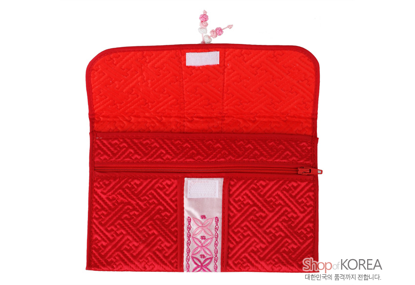 [텍스트: Shop of KOREA 대한민국의 품격까지 전합니다.] 붉은 비단 누비 바탕에 길상문 양각을 넣고, 중앙 분홍색 자수 띠와 지퍼 포켓이 더해진 전통 여권·통장 지갑 디자인