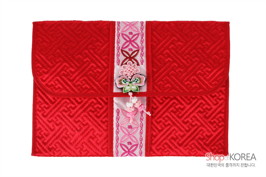 [텍스트: ShopofKOREA 대한민국의 품격까지 전합니다.] 붉은 비단 누비 바탕에 전통 길상문 양각 처리, 중앙 분홍색 자수 띠와 나비·매듭 장식이 조화를 이루는 여권·통장 지갑형 디자인