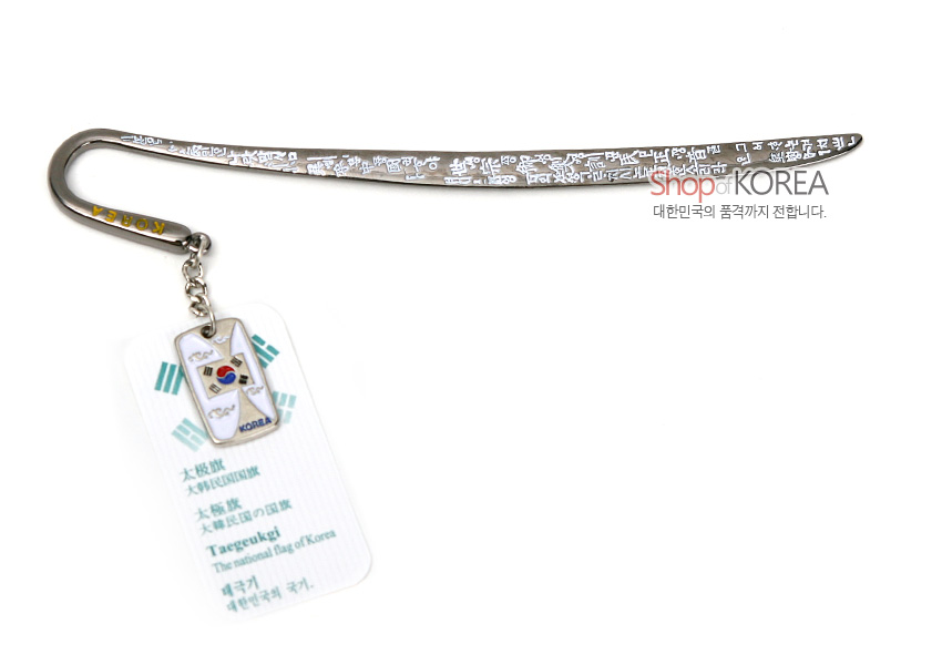 [텍스트: Shop of KOREA / Taegeukgi The national flag of Korea] 금속 재질 곡선형 책갈피에 한글 문자 문양을 양각한 디자인과 태극기 에나멜 장식 펜던트가 연결된 구성
