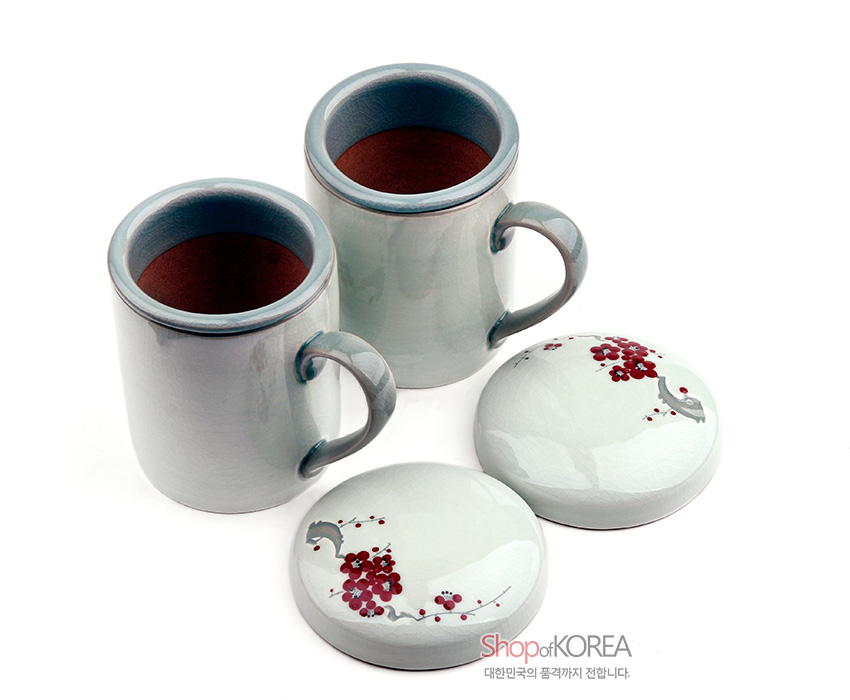 [텍스트: Shop of KOREA 대한민국의 품격까지 전합니다] 옅은 청자색 유약의 도자 머그와 붉은 매화 가지 문양이 그려진 둥근 뚜껑이 조화를 이루는 2인 머그세트 이미지 설명