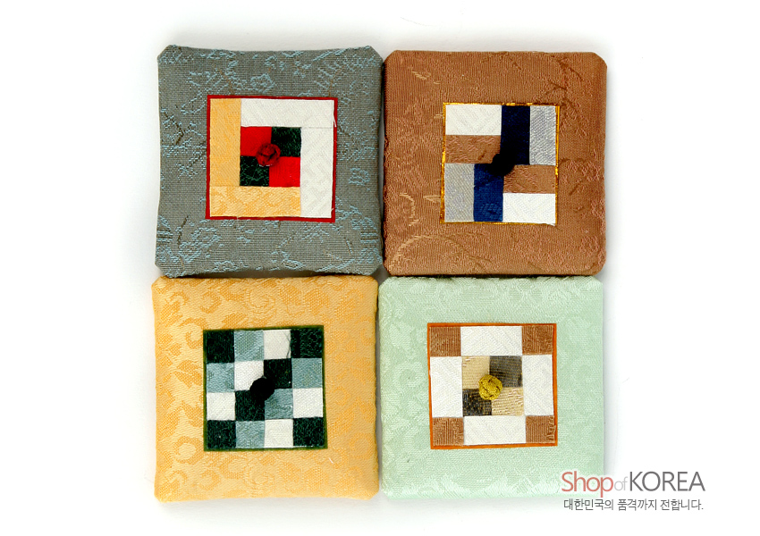 [텍스트: Shop of KOREA 대한민국의 품격까지 전합니다.] 옅은색 비단 바탕 위 전통 조각보 기법의 사각 패치와 색실 연봉매듭 장식 자석 구성 이미지
