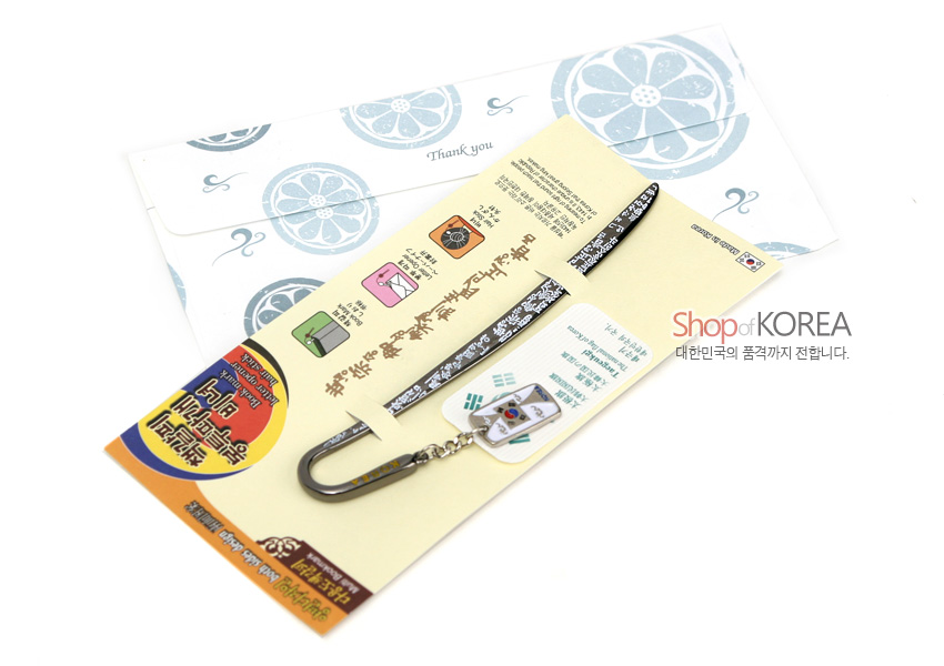 [텍스트: Thank you / Shop of KOREA 대한민국의 품격까지 전합니다.] 금속 재질 비녀형 책갈피와 태극기 사각 참 장식 구성, 흑색 바탕에 백색 전통문양 장식, 연한 노랑 패키지와 전통 문양 봉투 포함 이미지 설명