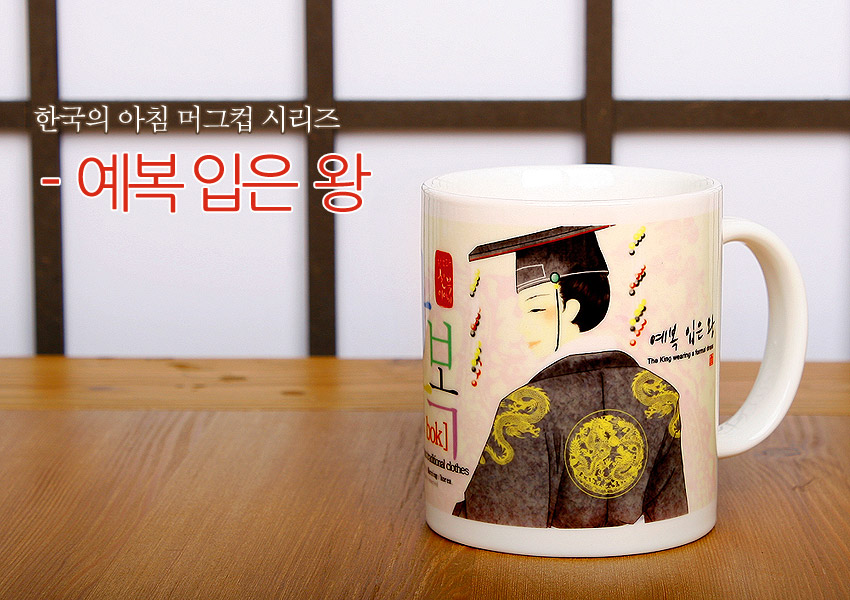 [텍스트: 한국의 아침 머그컵 시리즈 - 예복 입은 왕, bok!, The King wearing a formal dress] 흰색 세라믹 머그컵에 전통 예복 입은 왕 일러스트와 황금색 용 원형 문양, 파스텔 배경 색감이 조화를 이룬 디자인 묘사