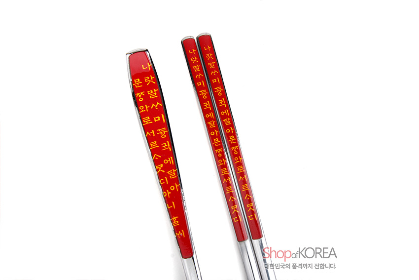 [텍스트: 나랏말ᄊ…] 붉은색 손잡이에 노란색 훈민정음 글자를 인쇄한 금속 수저와 젓가락 손잡이 디테일 이미지