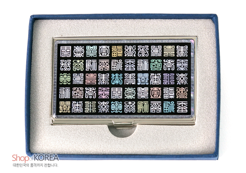[텍스트: Shop of KOREA 대한민국의 품격까지 전합니다.] 금속 테두리 위 흑색 바탕에 다채로운 자개 상감 사각 전서 한자 문양을 격자 배열한 직사각 명함집 이미지 설명