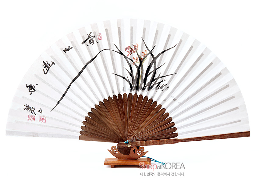 [텍스트: Shop of KOREA / 대한민국의 품격까지 전합니다.] 흰 한지에 수묵 채색 난초와 한자 서예, 붉은 낙관을 더한 전통 오죽선, 대나무 살대와 청색 매듭 장식의 조화가 돋보이는 디자인