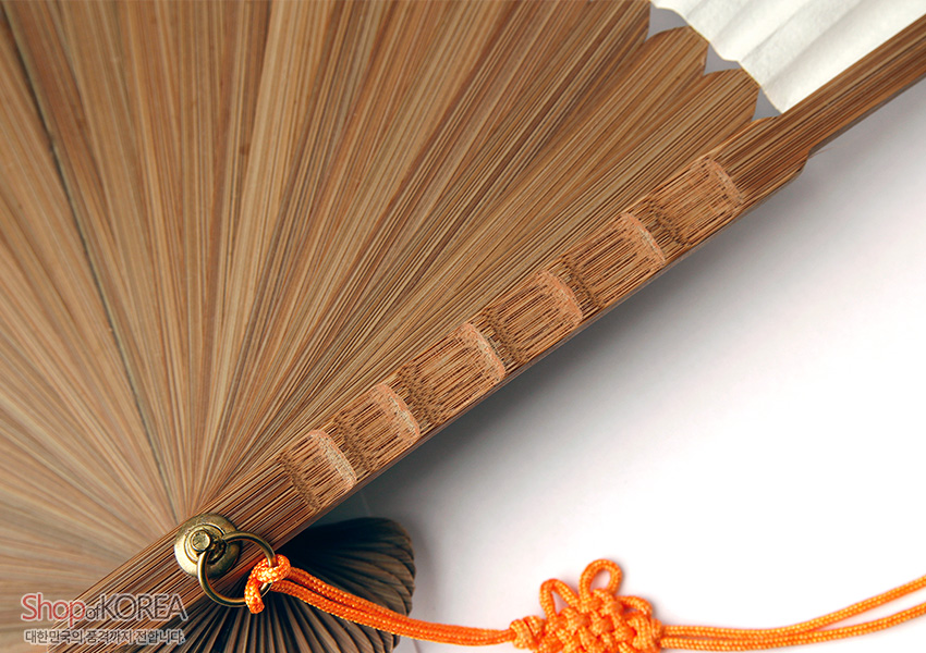 [텍스트: Shop of KOREA / 대한민국의 품격까지 전달합니다] 미세한 결이 살아있는 대나무 살대로 이루어진 합죽선 구조와 황동 고리, 주황색 전통 매듭 장식이 조화를 이루는 부채 디테일 이미지