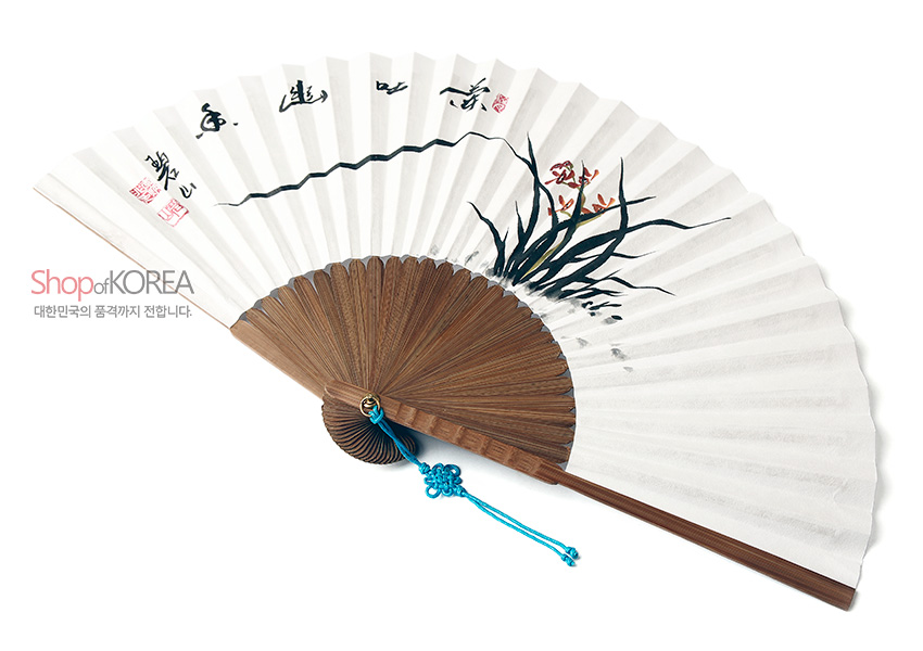 [텍스트: Shop of KOREA / 대한민국의 품격까지 전합니다.] 흰 한지 위 수묵채색 난초와 한자 서예, 붉은 낙관이 더해진 오죽선과 청색 매듭 장식 특징의 전통 접선 이미지 설명