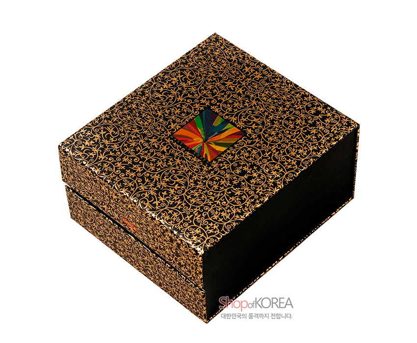 [텍스트: ShopofKOREA 대한민국의 품격까지 전합니다.] 금색 덩굴무늬로 장식된 검정 바탕 포장 박스와 중앙 다채로운 색상의 사각 장식이 있는 이미지