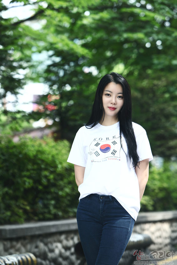 [텍스트: KOREA, Korean flag T-shirts] 흰색 면 티셔츠 중앙 태극 문양과 사괘를 3D 입체 발포 기법으로 표현한 전면 디자인, 자연 배경 속 착용 모습 연출