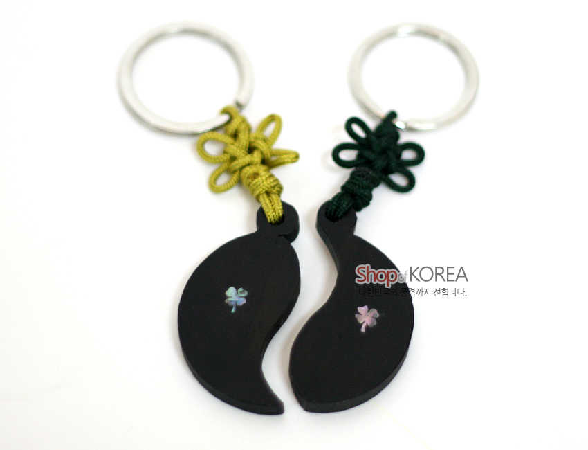 [텍스트: Shop of KOREA 대한민국의 혼을 전세계까지 전합니다.] 흑단 바탕 반달형 열쇠고리에 자개 상감 연꽃 문양 장식, 녹색·황색 전통 매듭과 금속 고리 구성