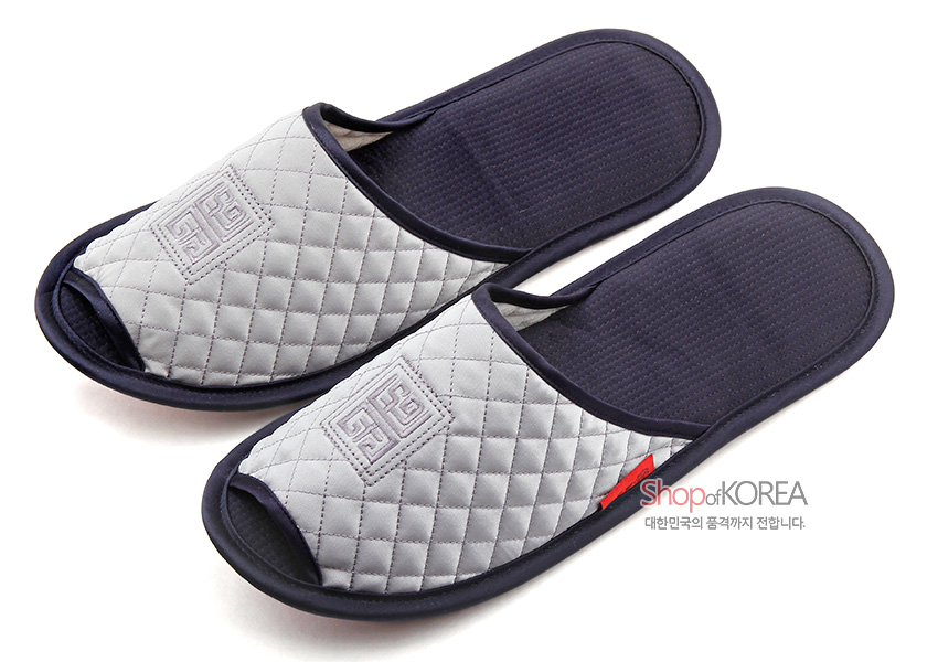 [텍스트: Shop of KOREA / 대한민국의 품격까지 전합니다.] 남색 바탕과 연회색 퀼팅 누빔 천이 배색된 슬리퍼, 앞코 전통 기하학 문양 자수 장식 실내화 이미지